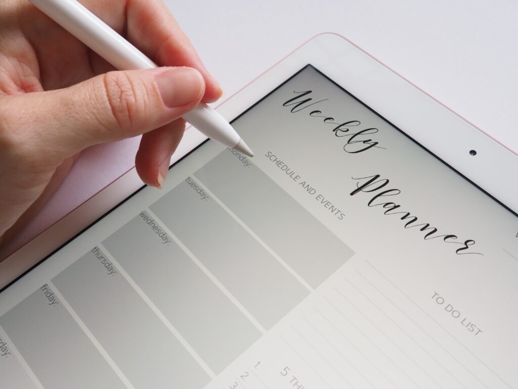 a person planning their week on a digital planner